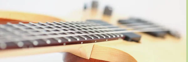 Close-up of luxury wavy shape of wooden electric guitar with rosewood neck. Six stringed musical instrument. Music, hobby, leisure, art, talent concept