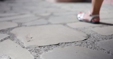 Human leg is walking and falling down with cigarette butt. Harm of smoking and street garbage