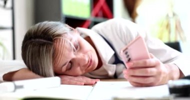 Yorgun doktor masaya uzanır ve ne yazık ki akıllı telefona bakar. Fazla mesai ve sağlık görevlisi