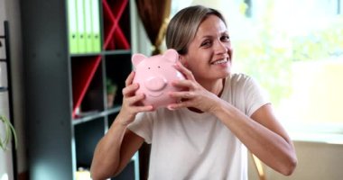 Gülümseyen, başarılı genç bir kadının portresi, ellerinde apiggy bankasını kırıyor. Yatırım kredileri mevduatlar ve finansman ve zenginlik ve birikim.