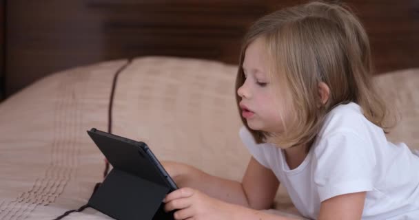 Kleines Mädchen Liegt Mit Tablet Bett Und Blickt Auf Bildschirm — Stockvideo