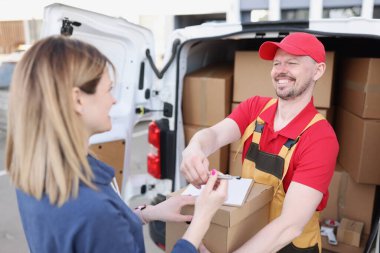 Sokaktaki mutlu kadın kuryeden bir paket alır. Salgın sırasında hedeflenen mal teslimatı