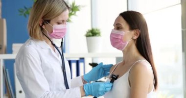 Koruyucu maskeli doktor ve hasta steteskoplu akciğerleri dinler. Zatürree ya da öksürük konsepti olan grip.