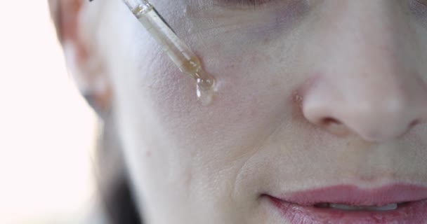 Kvinna Gräver Ansiktet Med Transparent Olja För Att Återfukta Huden — Stockvideo