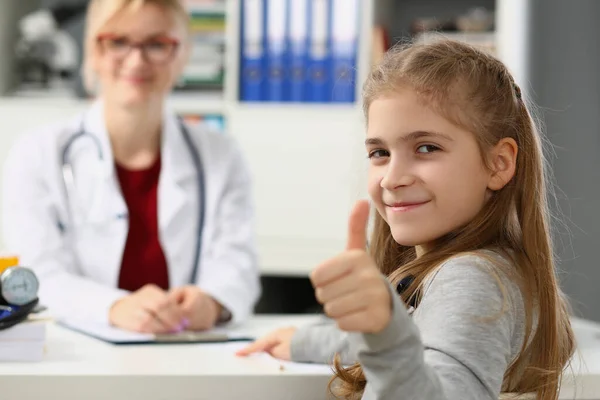 Gyönyörű Kislány Felemeli Hüvelykujját Orvos Háttérben Egészségbiztosítás Gyermekvizsgálat — Stock Fotó