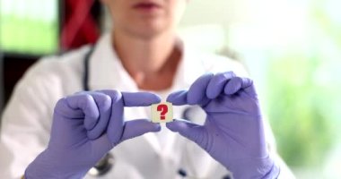 Doktor, üzerinde soru işareti olan mavi lastik koruyucu eldiven verdi. Tıbbi konular kavramı