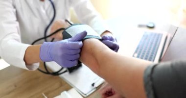 Doktor kan basıncını ölçmek için insan koluna tonometre koyuyor. Kan basıncı ve kalp hastalığı kardiyolojisi