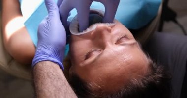Ortodontist kadın yüzüne ve protezlere diş kemeri takıyor. Isırık, eklem ve kaplama kaplaması yerleştirmeden önce ısırık izlerinin düzeltilmesi.