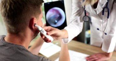 ENT otorhinolaryngologist kadın erkeğin kulağını inceliyor. Kulak ağrısı ve işitme testi