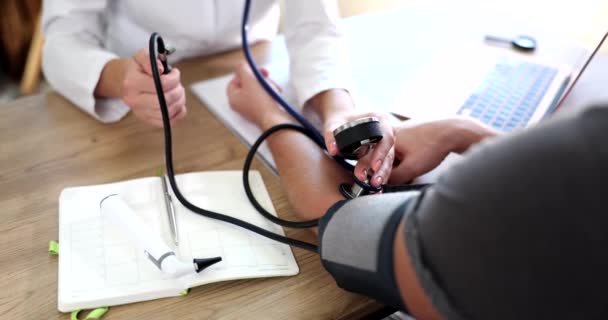 心脏病医生在餐桌上检查一个男人的血压 动脉高血压的治疗 — 图库视频影像