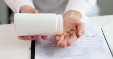 Kadın doktor eline omega-3 balık yağı kapsülü döküyor. Omega 3 doymamış yağ asitleri sağlık faydaları