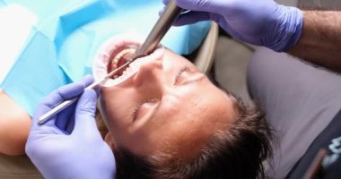 Diş hekimi hasta dişlerini temizler ve seramik kaplamalar takar. Diş bakımı ve tedavisi