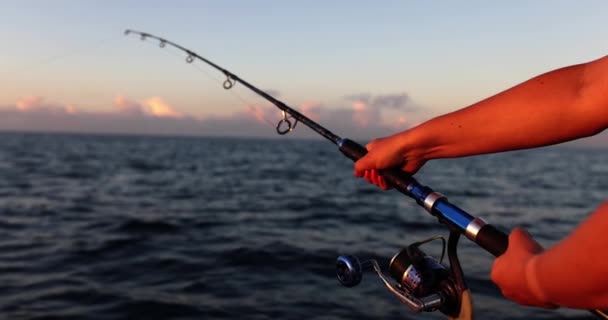 漁師と漁師の手は回転棒とリールハンドルを保持します 趣味と活動と海釣り — ストック動画