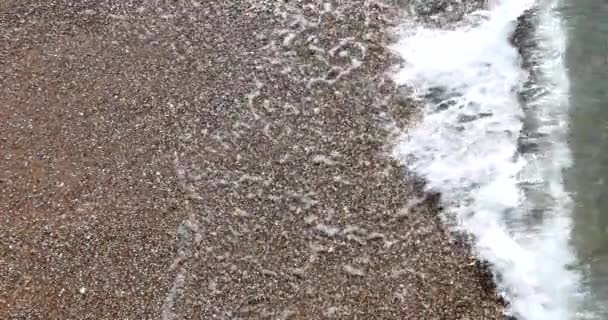 小さな小石の海の水を閉じます 海岸に波のある小さな石 — ストック動画