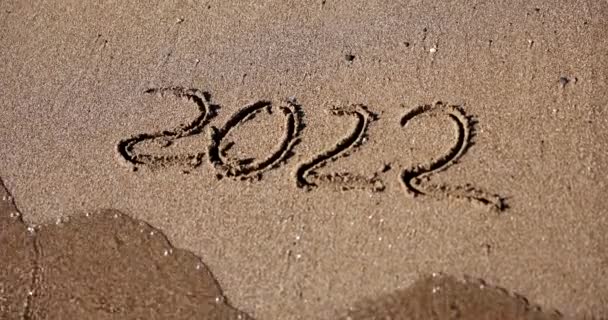 2022年に砂の上に描かれた数字は波によって洗い流されます 2022年末から2023年初頭 — ストック動画