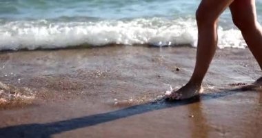Kadın ve erkek bacakları deniz kıyısında yürüyor. Balayı aşkı buluşması ve seyahat konsepti.