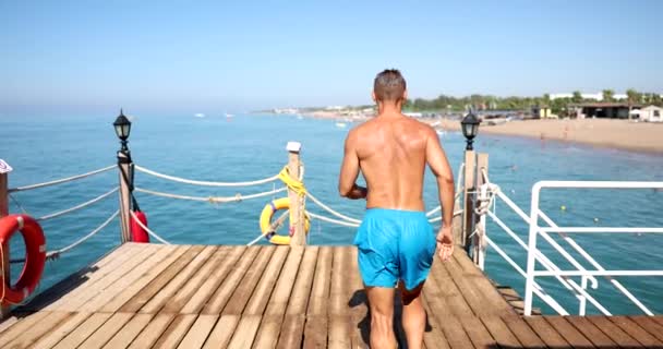 Vista Posteriore Del Giovane Sportivo Che Salta Mare Dal Molo — Video Stock