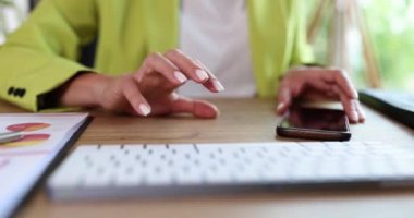 Ofisteki analist kadın parmaklarını masaya vuruyor, yakın plan. Bilgi eksikliği, telefon beklemek.