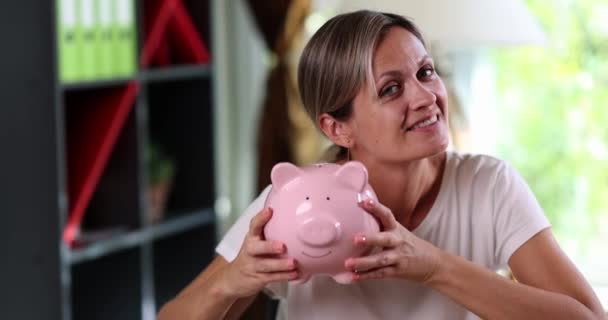 Usmívající Žena Tričku Zatřese Růžovou Svinčíkem Zblízka Radost Finančních Úspor — Stock video