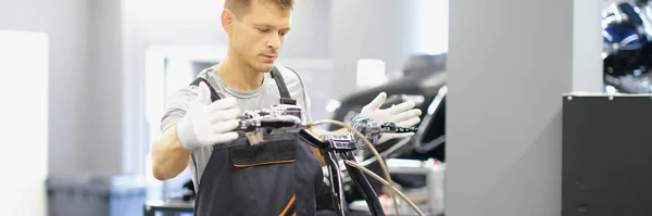 A man repairs the steering wheel of a motorcycle. Motorcycle club service center, bike repair in the garage