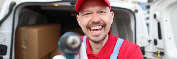 Mensageiro Uniforme Vermelho Mostra Uma Ferramenta Perto Uma Van Coberta — Fotografia de Stock