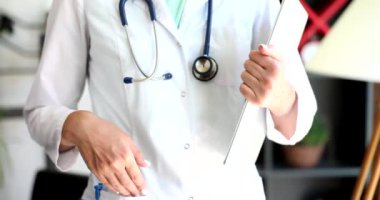 Dosyaları ve doktor eli olan doktor hasta kayıtlarını tutuyor. Tıbbi yardım sigortası ve muayene