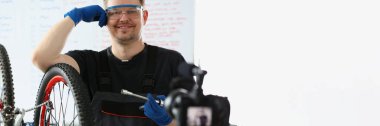Mutlu tamircinin portresi bozuk bisikleti tamir etmeye çalışır, video kameradaki film süreci, mekanik başlatma çevrimiçi kanalı. Blogcu, içerik, hobi, yaratıcı konsept