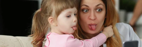 Retrato Madre Hija Muestran Lenguas Cámara Divirtiéndose Tomando Selfie Teléfono — Foto de Stock