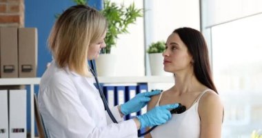Doktor steteskopla hastanın kalp atışlarını ve akciğerlerini dinliyor. Kronik öksürük ve teşhis konsepti