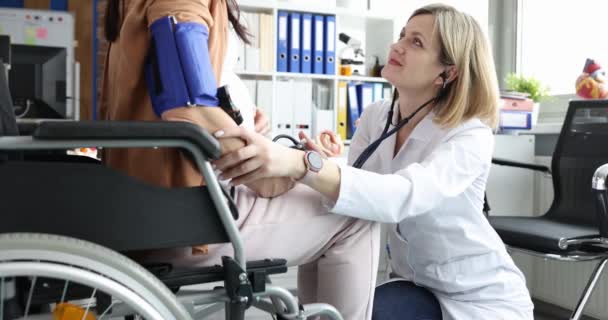 医師は車椅子で妊婦の血圧を測定します 体外受精と障害の概念 — ストック動画
