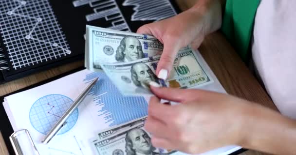 女商人在有图表的文件上数着美元钞票 这是4K部电影的慢镜头 从成功的商业概念中获利 — 图库视频影像