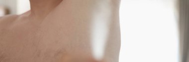 İnsan terleme önleyici kullanarak yakın plan çekimde, insan koltukaltına vücut spreyi sıkar. Güzel kokmak için deodorant sıkmak. Sağlık, vücut bakımı, hijyen, rutin konsept