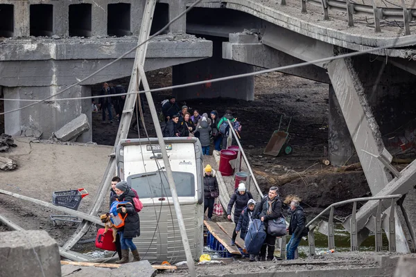 Irpin, Kyiv bölgesi, Ukrayna - 6 Mart 2022: Yerel halk Rus birliklerinin bombalanması sırasında yıkılmış köprü altında şehri boşaltmaya çalışıyor. Rus ordusu Ukrayna 'da sivilleri vurdu