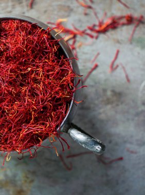 Klasik cupronickel kaplamalı Saffron baharatı metal arka planda, koyu renkli fotoğraf, açık diyafram.