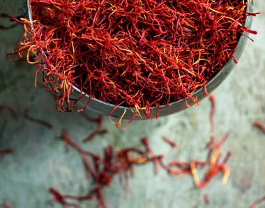 Klasik cupronickel kaplamalı Saffron baharatı metal arka planda, koyu renkli fotoğraf, açık diyafram.