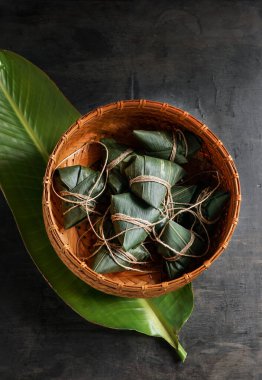 Zongzi Rice, Çin geleneksel ejderha botu festivali için siyah arka planda buharlı börek yapıyor.