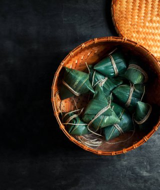 Zongzi Rice, Çin geleneksel ejderha botu festivali için siyah arka planda buharlı börek yapıyor.