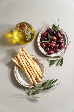 Kalamata zeytinyağı, Aceitunas Kalamon ve Grissini ekmekleri, zeytinyağı. Akdeniz atıştırmalıkları beyaz modern tarzda, üst görünüm