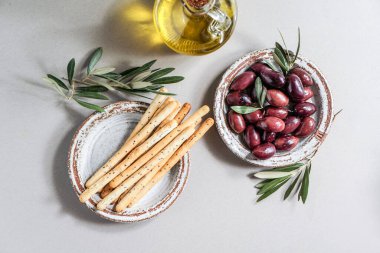 Kalamata zeytinyağı, Aceitunas Kalamon ve Grissini ekmekleri, zeytinyağı. Akdeniz atıştırmalıkları beyaz modern tarzda, üst görünüm