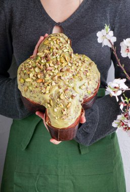 Kadında Kolomba di Pasqua, el çırpma, geleneksel İtalyan paskalya güvercini pastası, yeşil şam fıstığı jölesi, taze bahar çiçekleri, pasqua keki.