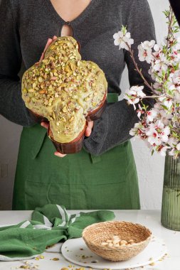 Kadında Kolomba di Pasqua, el çırpma, geleneksel İtalyan paskalya güvercini pastası, yeşil şam fıstığı jölesi, taze bahar çiçekleri, pasqua keki.