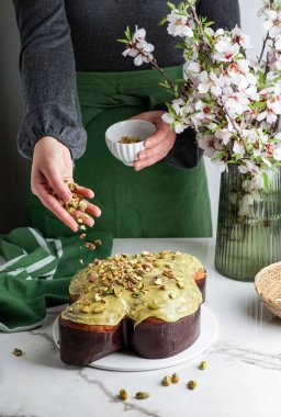 Kadında Kolomba di Pasqua, el çırpma, geleneksel İtalyan paskalya güvercini pastası, yeşil şam fıstığı jölesi, taze bahar çiçekleri, pasqua keki.