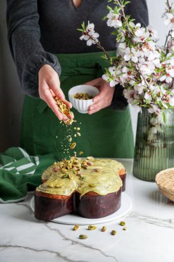 Kadında Kolomba di Pasqua, el çırpma, geleneksel İtalyan paskalya güvercini pastası, yeşil şam fıstığı jölesi, taze bahar çiçekleri, pasqua keki.