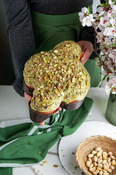 Kadında Kolomba di Pasqua, el çırpma, geleneksel İtalyan paskalya güvercini pastası, yeşil şam fıstığı jölesi, taze bahar çiçekleri, pasqua keki.