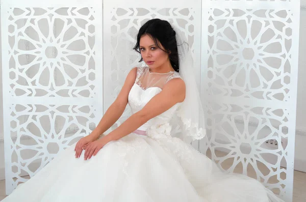 Panna młoda w białej sukni ślubnej w jasnym pokoju — Zdjęcie stockowe