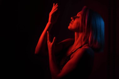 Sarışın bir kızın portresi. Kırmızı ve mavi ışıklı bir odada.