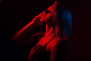 Sarışın bir kızın portresi. Kırmızı ve mavi ışıklı bir odada.