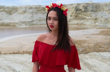 beautiful brunette girl in a bright red dress in the desert