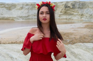 beautiful brunette girl in a bright red dress in the desert