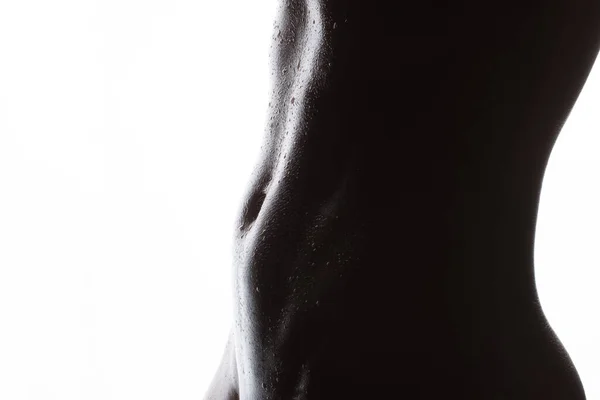 Female athletic figure.body and abdominal press with water drops close-up on a white background. — ストック写真